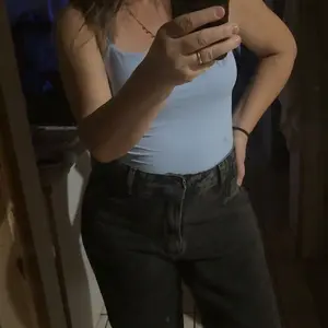 Cliente usando calça wide leg jeans preta