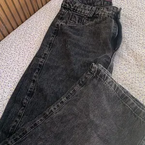 Cliente usando calça wide leg jeans grafite vista traseira